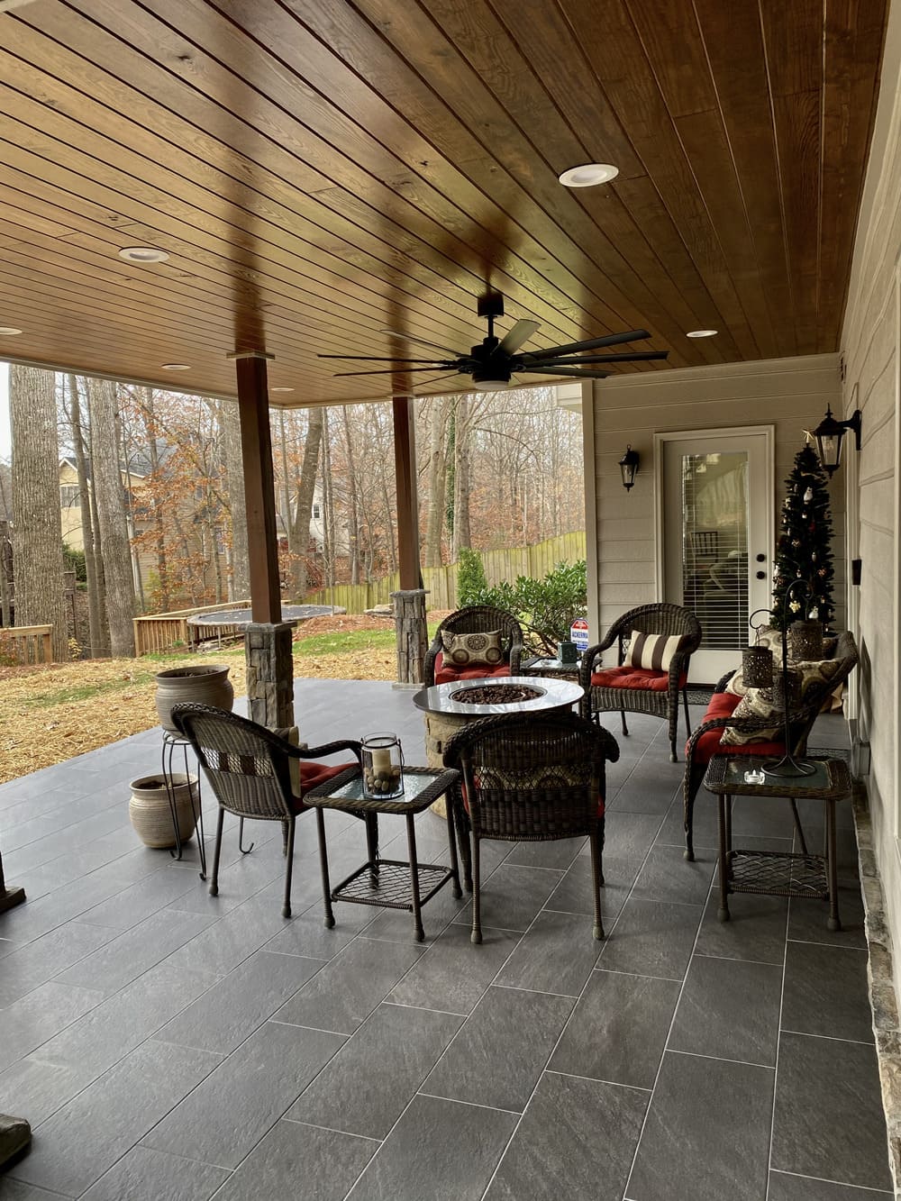 Covered patio with outdoor fire pit and forest view on it