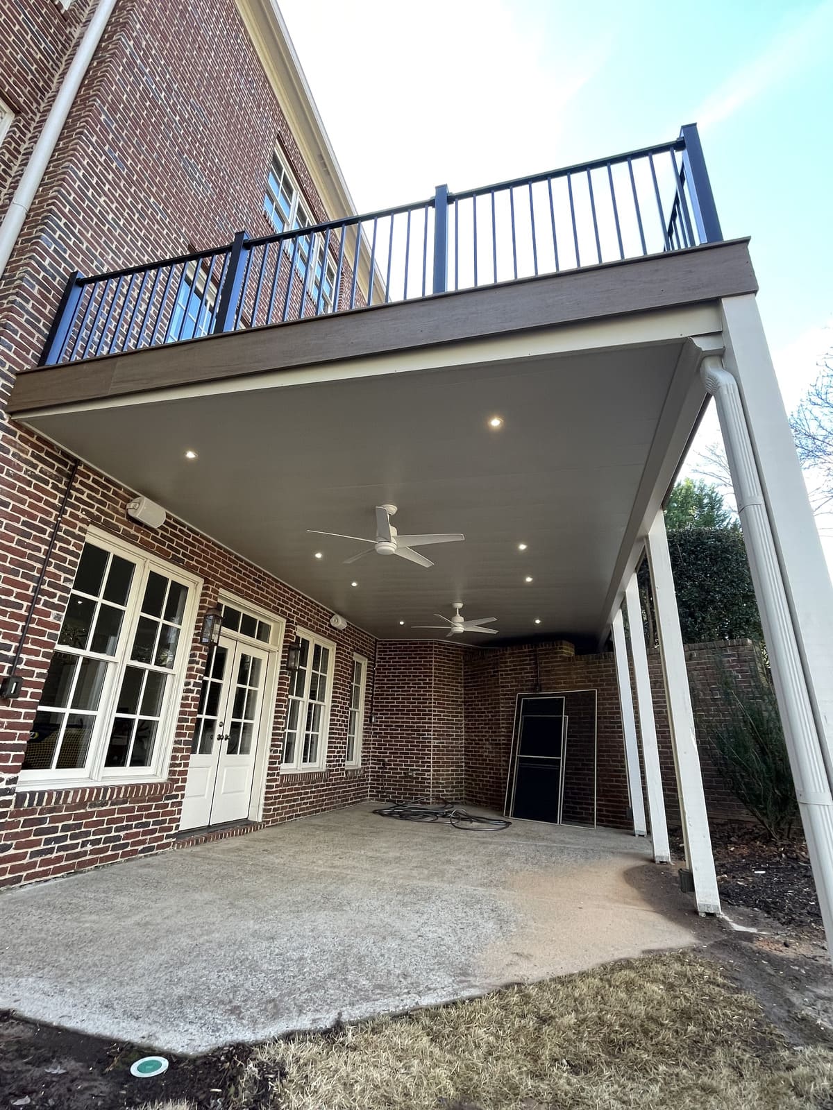 Elevated deck with black railing and have a fan and lights on the bottom side