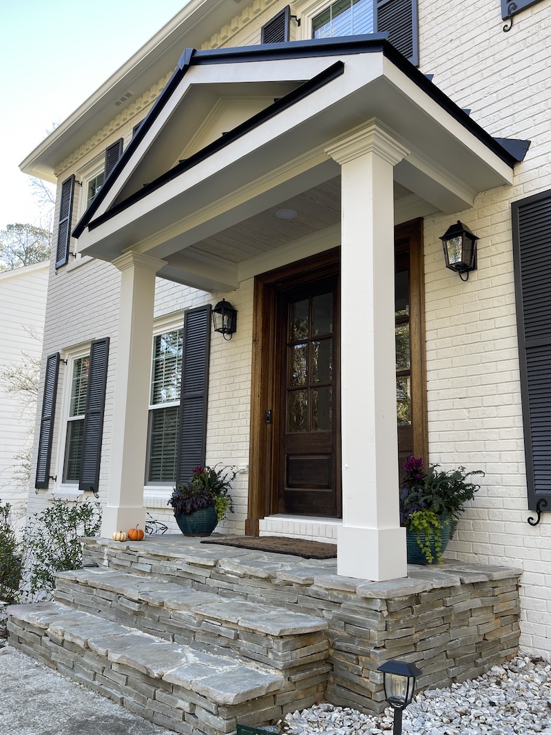 Portico with wooden door and lighting on it