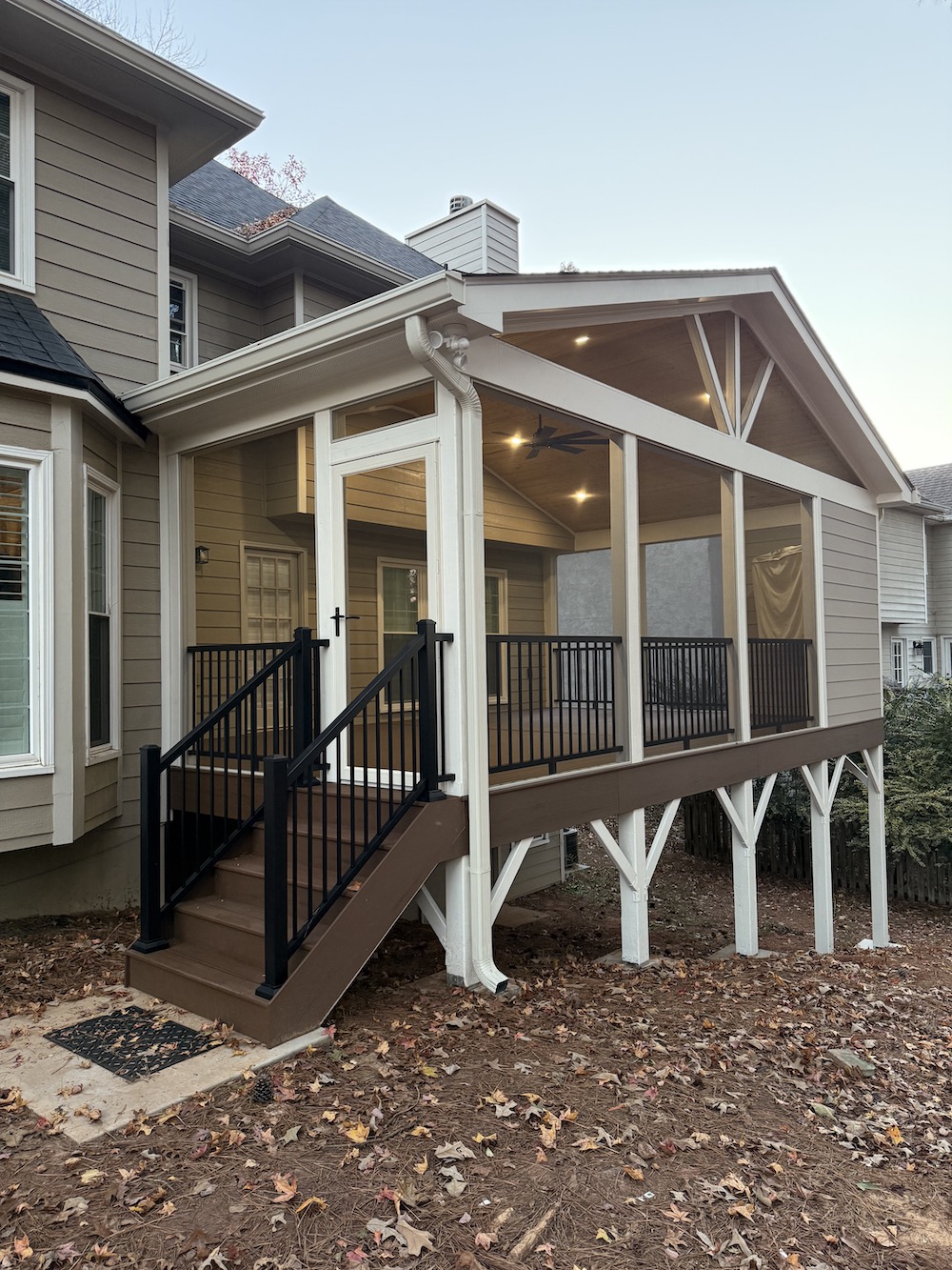 Raised dark deck with black railing on the porch